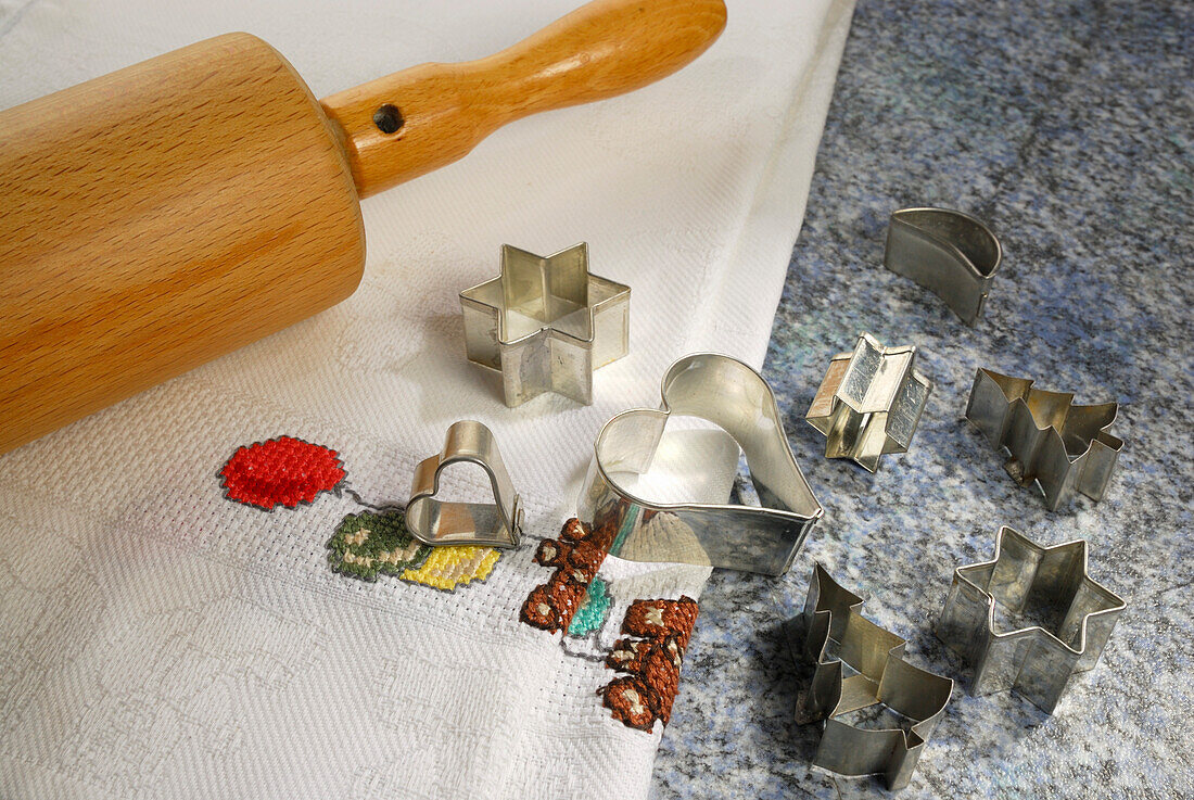Cookie cutters for Christmas cookies and rolling pin laying on worktop