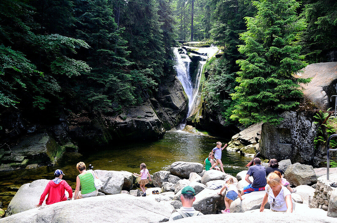 People on rocks at the Kochel falls in the sunlight, Bohemian mountains, Lower Silesia, Poland, Europe