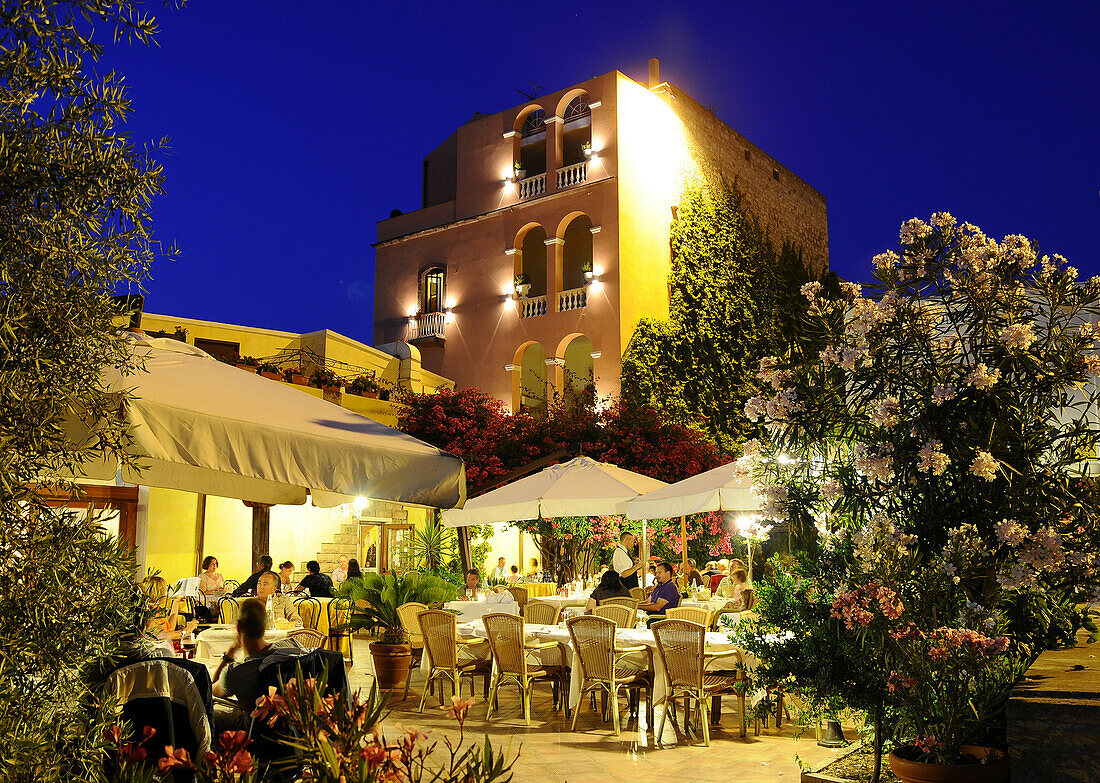 People at the illuminated terrace of the Hotel Restaurant Sa Pischedda in the evening, Bosa, Sardinia, Italy, Europe