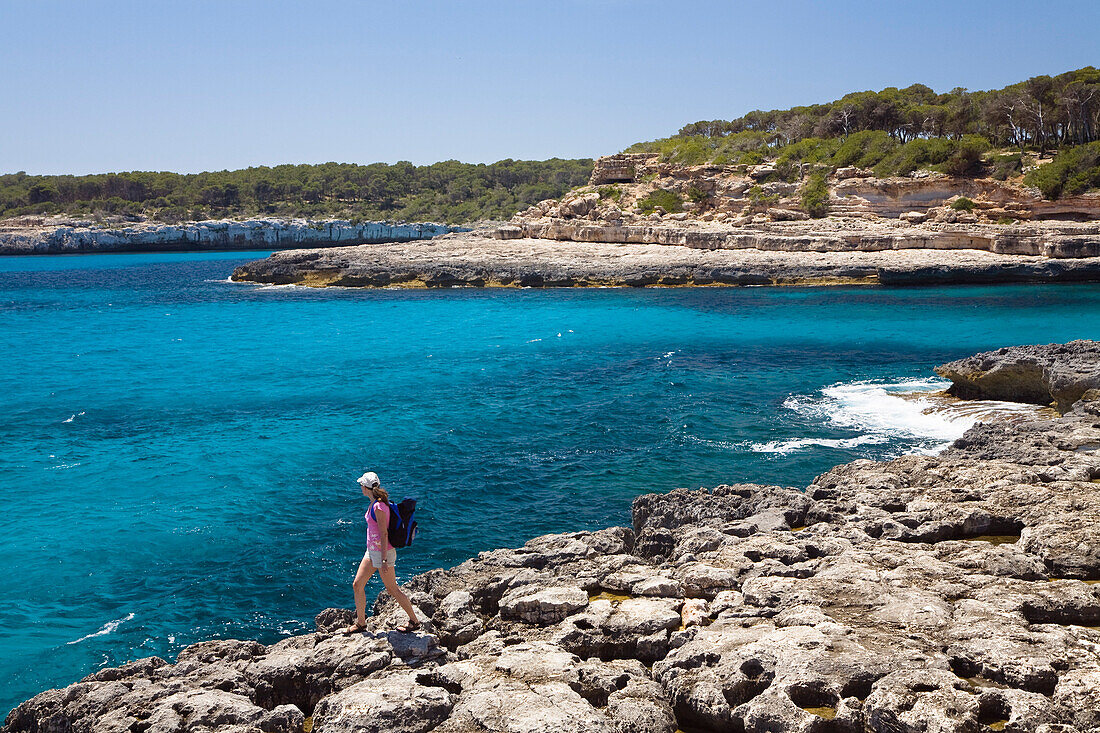 A woman on the cliffs in the bay Cala Mondragó, natural park of Mondragó, Mallorca, Balearic Islands, Mediterranean Sea, Spain, Europe