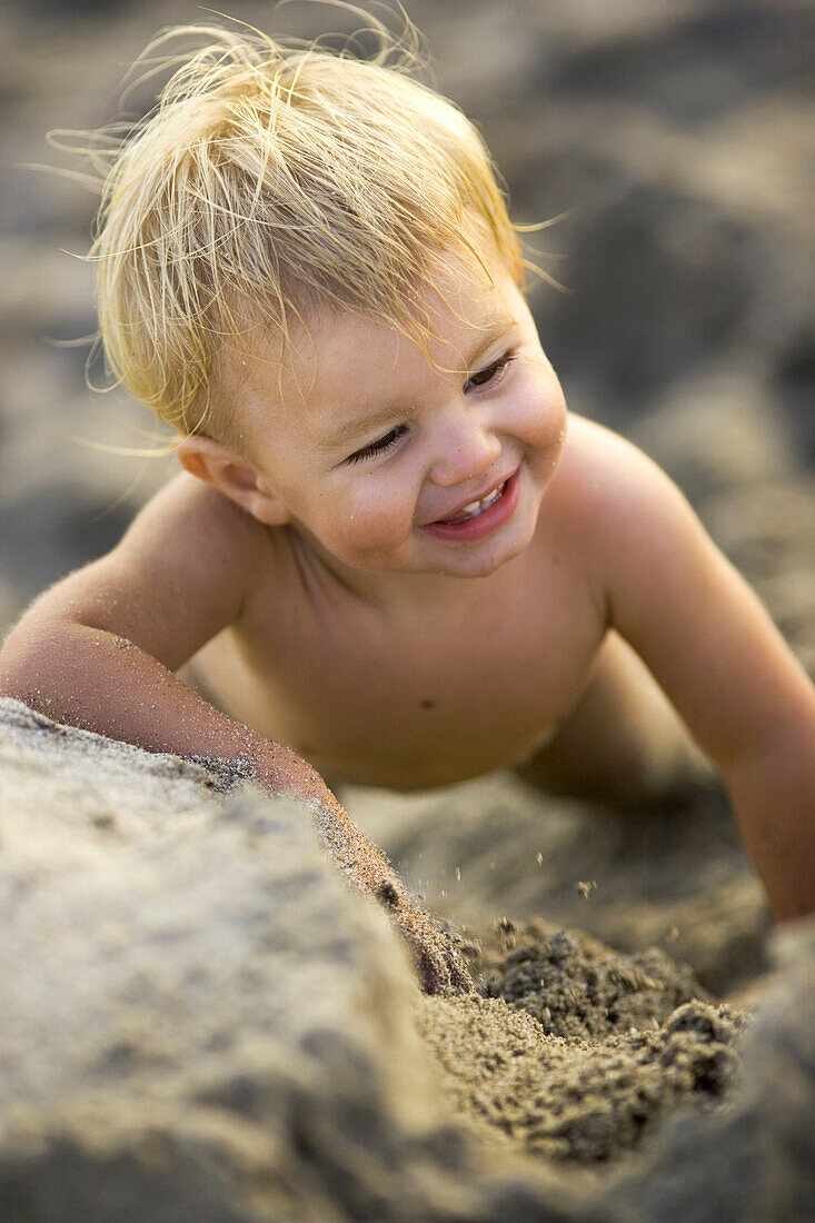 Lachendes kleines Mädchen spielt im Sand, Punta Conejo, Baja California Süd, Mexiko, Amerika