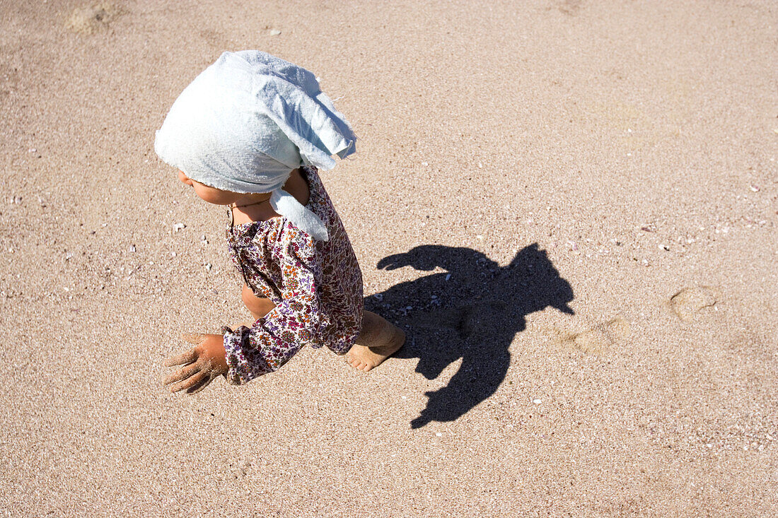 Blick von oben auf ein kleines Mädchen am Strand im Sonnenlicht, Punta Conejo, Baja California Sur, Mexiko, Amerika