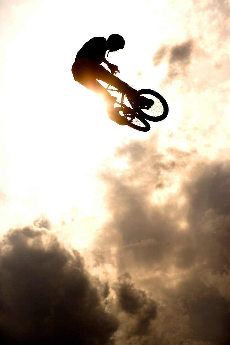 Young man jumps with BMX bike over ramp, Munich, Bavaria, Germany