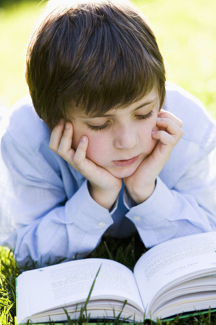 Boy reading a book in the garden
