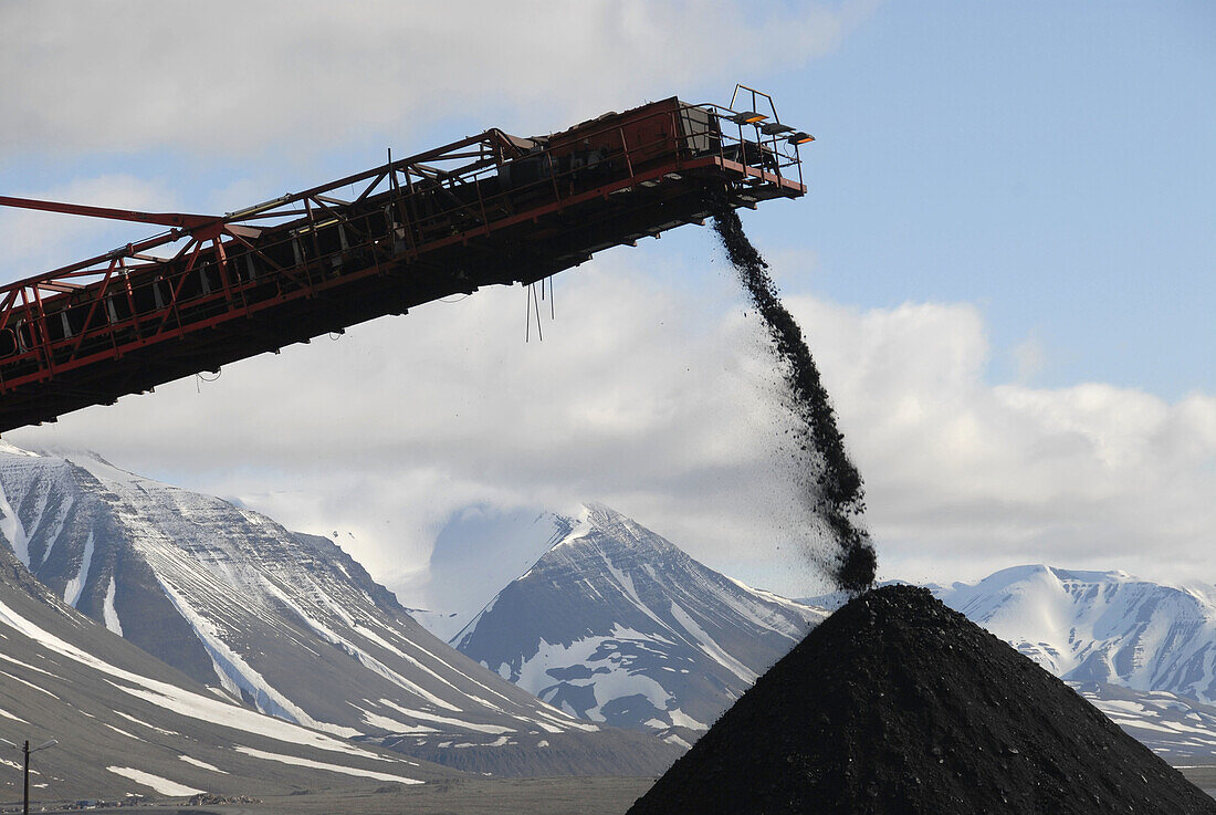 Mountain of coal pours out of mountain on a conveyor belt to be trucked to the port,  Svea coal mine,  Svalbard,  Norway