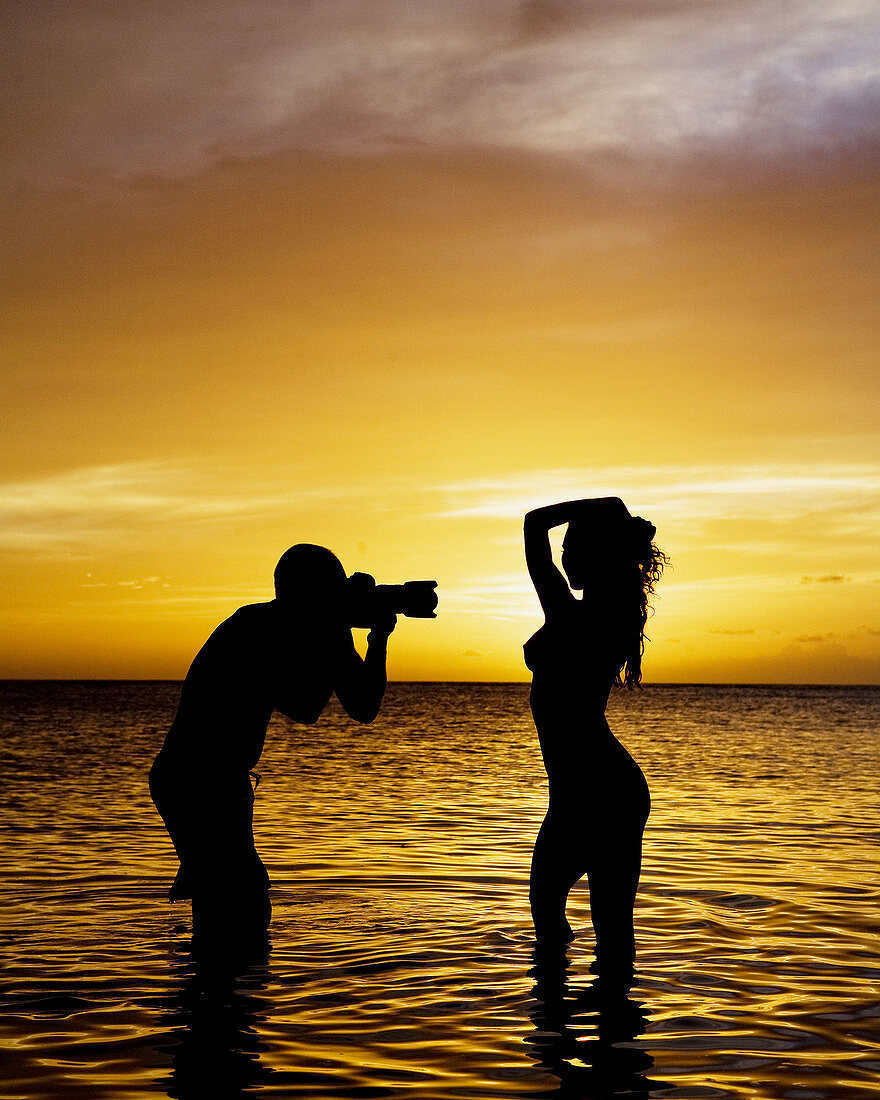 man shooting nude model in sunset.