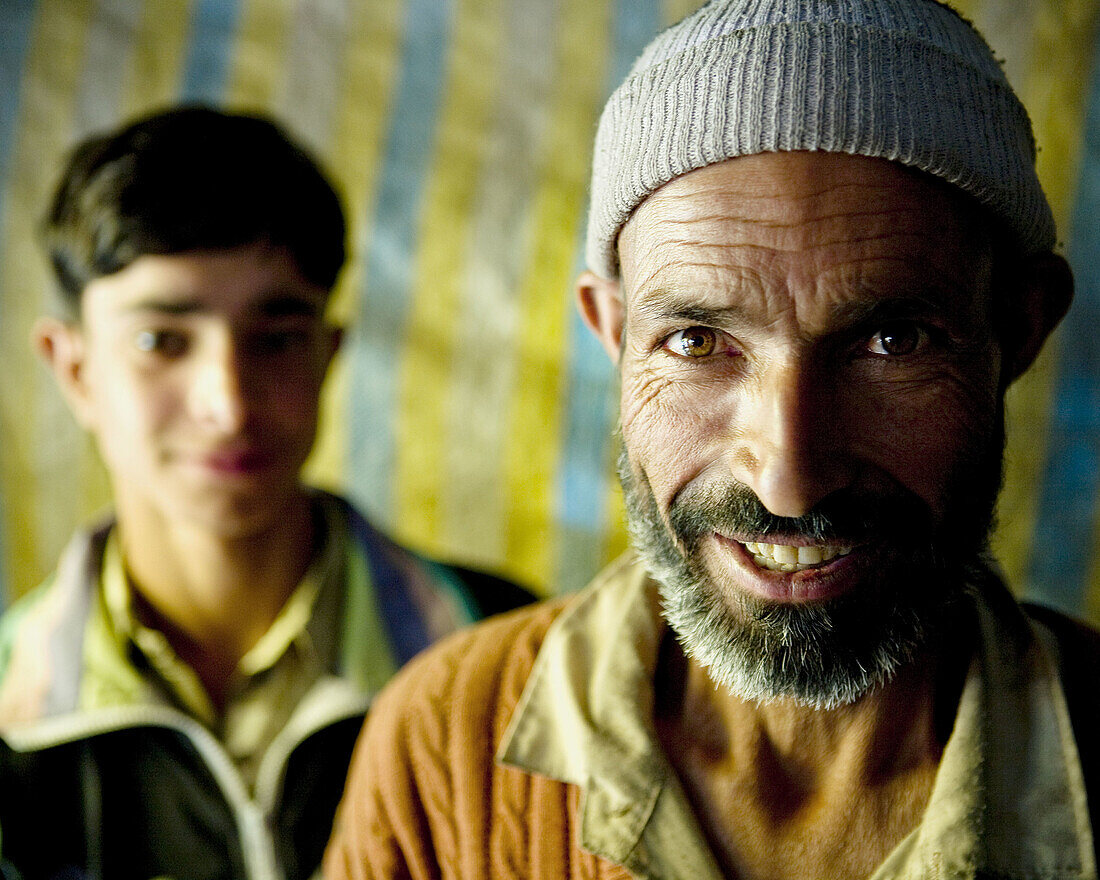 closeup portrait of a man in kashmir in focus and son out of focus in the background