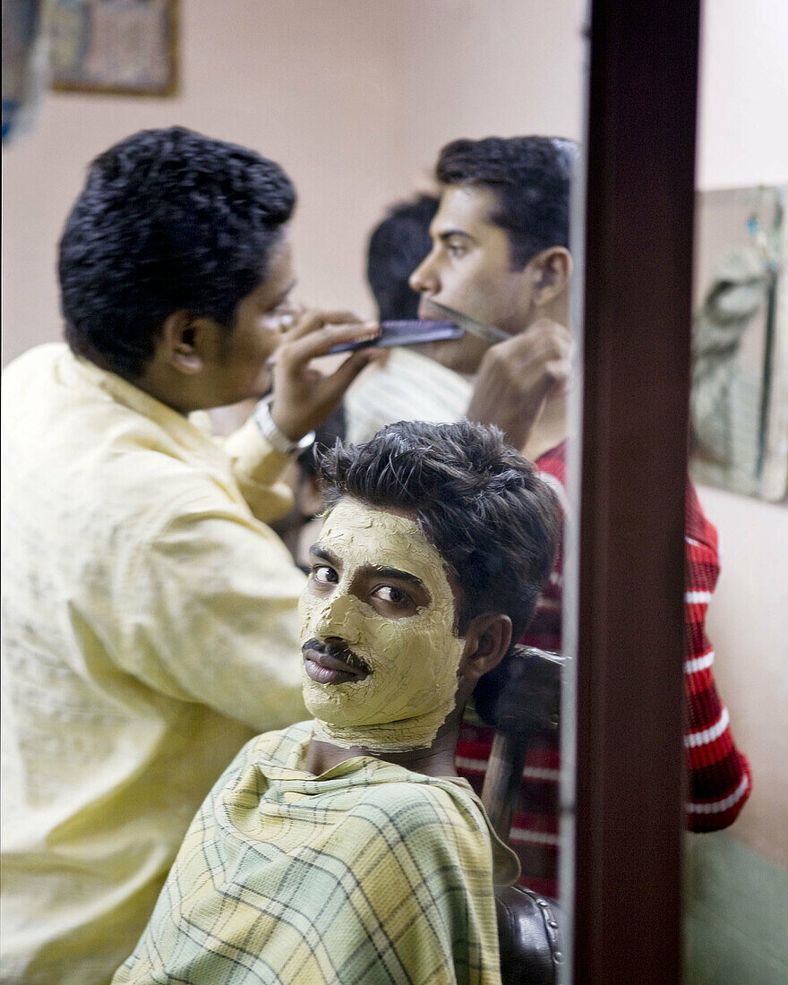 indian men in a barber shop getting facials.