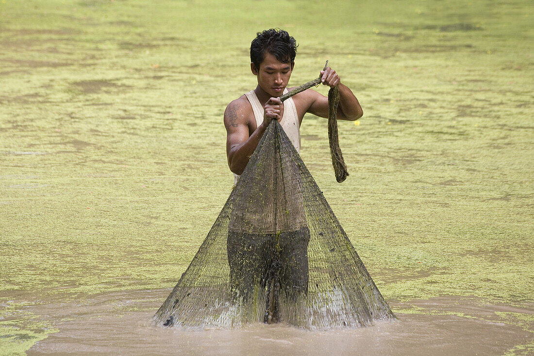 Cambodian fisherman with fishing net in a river, Angkor, Siem Reap Province, Cambodia, Asia
