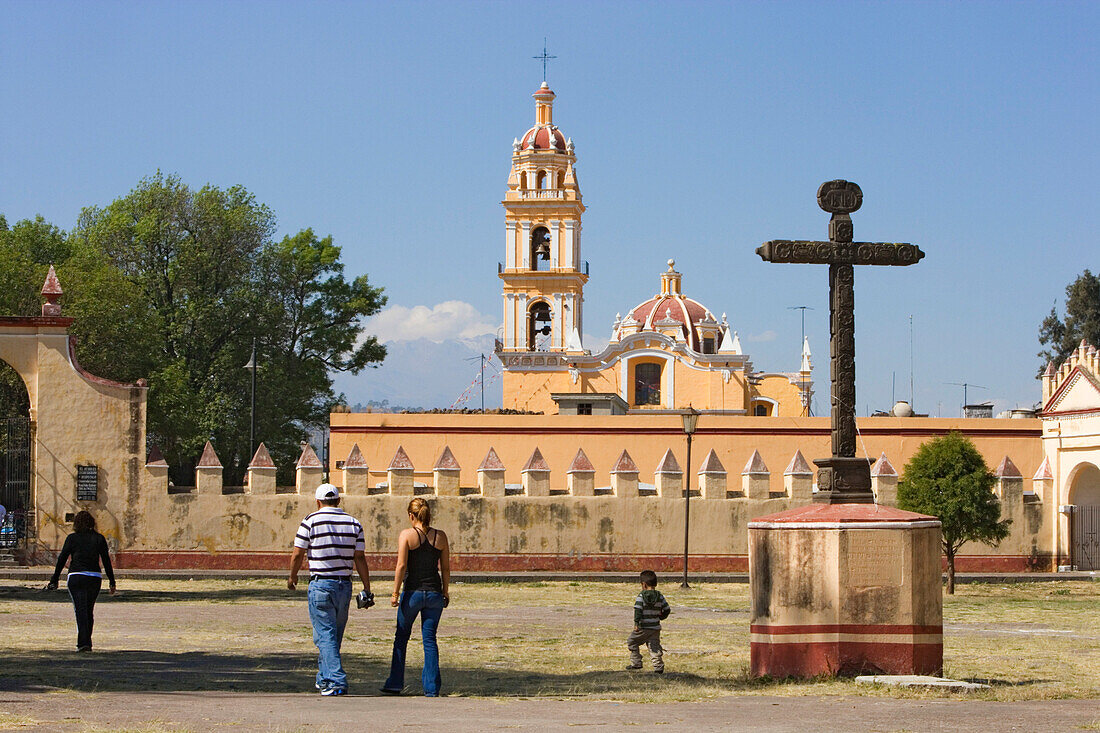 Familie läuft über den Vorplatz des Ex-Convento de San Gabriel, im Hintergrund ist die Iglesia de San Pedro, Cholula, Bundesstaat Puebla, Mexiko