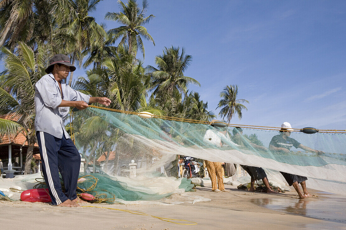 Fischer mit Fischernetz am Strand von Mui Ne, Provinz Binh Thuan, Vietnam, Asien