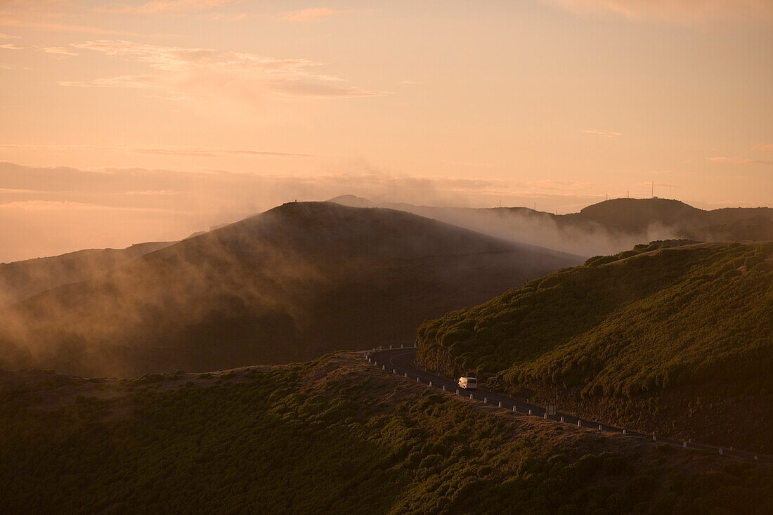 Hügel und Auto auf Straße bei Sonnenuntergang, nahe Rabacal, Paul da Serra Hochebene, Madeira, Portugal