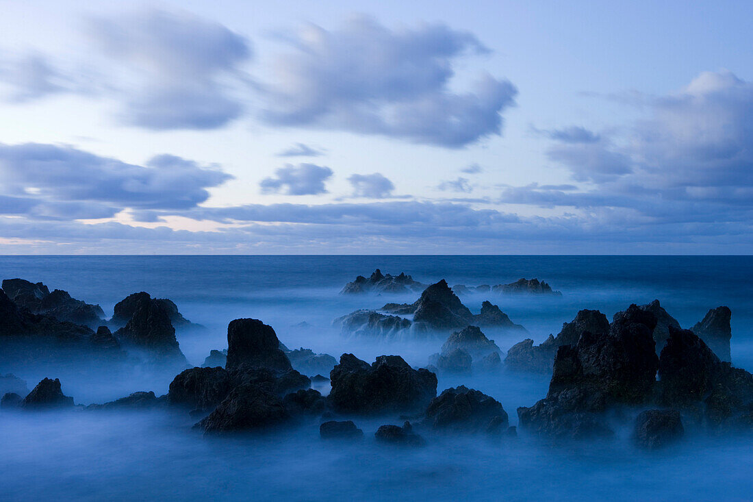 Lava rocks at dusk surrounded by sea water, Porto Moniz, Madeira, Portugal