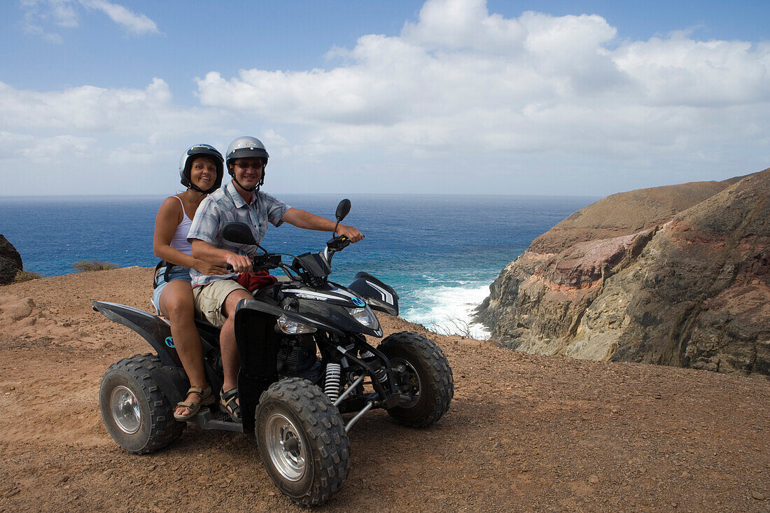 Couple on a quad all-terrain vehicle near Ponta da Canaveira, Porto Santo, near Madeira, Portugal