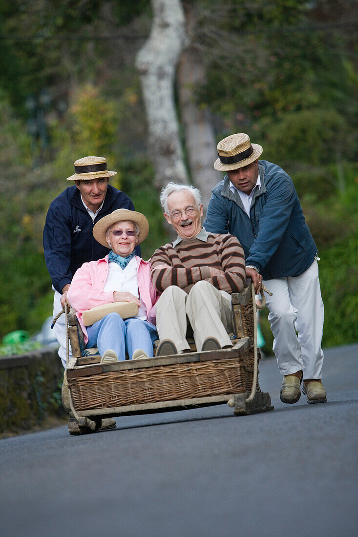 Älteres Paar genießt Korbschlittenfahrt in Monte, Funchal, Madeira, Portugal