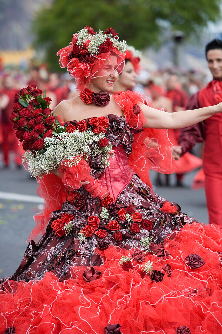 Mit roten Rosen geschmückte Frau beim alljährlich stattfindenden Madeira Blumenfest, Funchal, Madeira, Portugal