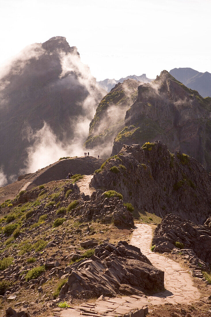 Hikers on a track between Pico do Arieiro and Pico Ruivo Mountains, Pico do Arieiro, Madeira, Portugal