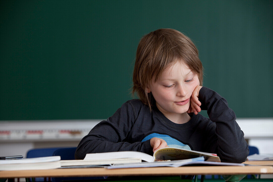 Schüler liest in einem Buch, Hamburg, Deutschland