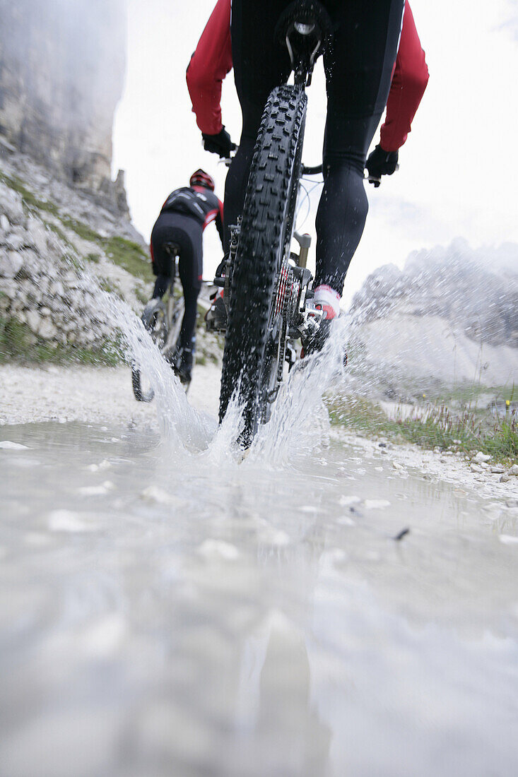 Persons mountain biking near Tre Cime di Lavaredo, Veneto, Italy