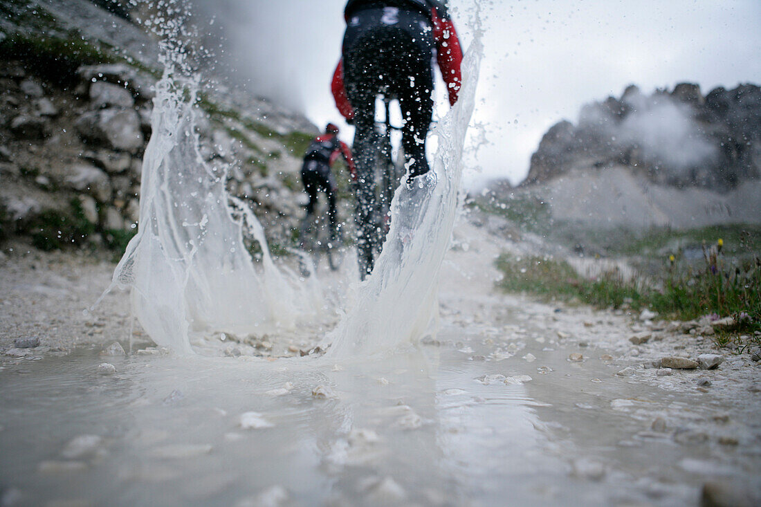 Persons mountain biking near Tre Cime di Lavaredo, Veneto, Italy