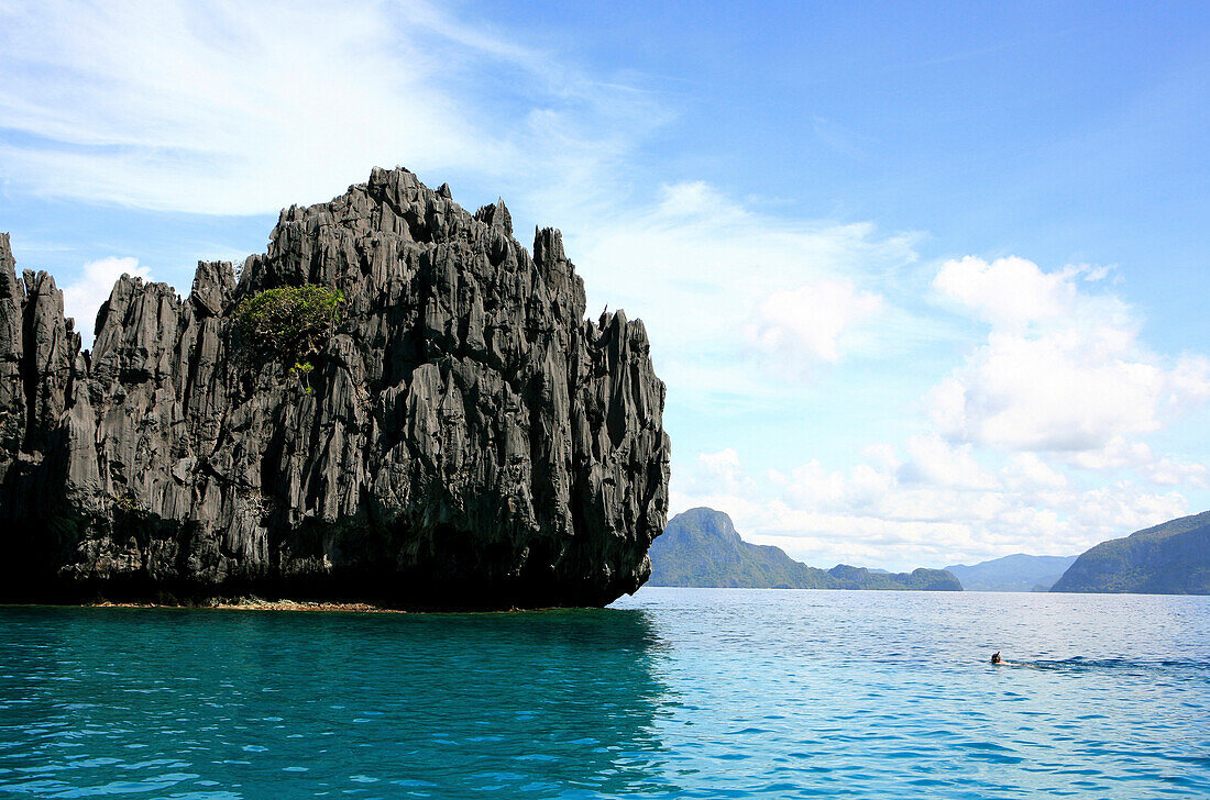 Kalksteinfels und Schnorchler in der Blue Lagoon im Bacuit-Archipel, El Nido, Palawan, Philippinen, Asien