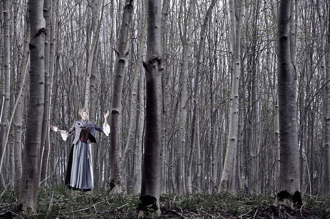 Young woman wearing a dirndl, standing in a forest, Kaufbeuren, Bavaria, Germany