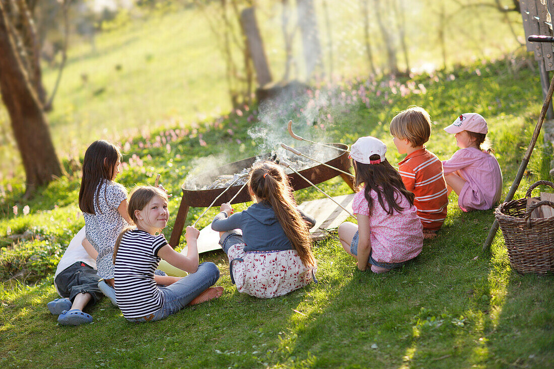 Children barbecueing sausages, Munsing, Bavaria, Germany