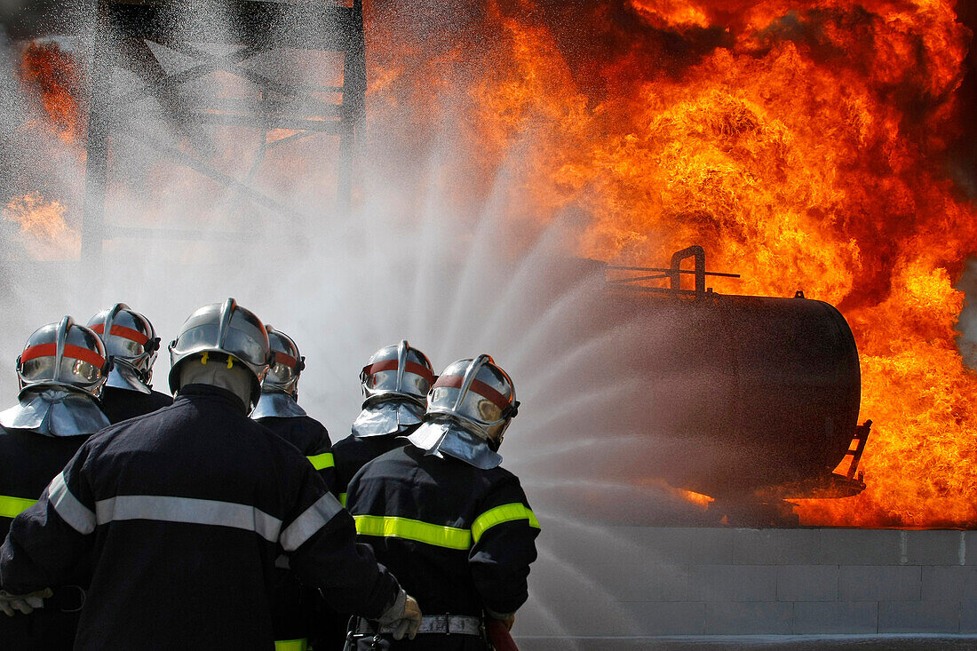 A Team With 2 Hoses Approaching A Fire On A Tanker At A Loading Station. Training Of The Firefighters Of The Sdis38 In Hydrocarbon Fires, Gesip (Study Group Of Safety In The Petrol And Chemical Industries) Of Roussillon, Isere (38), France