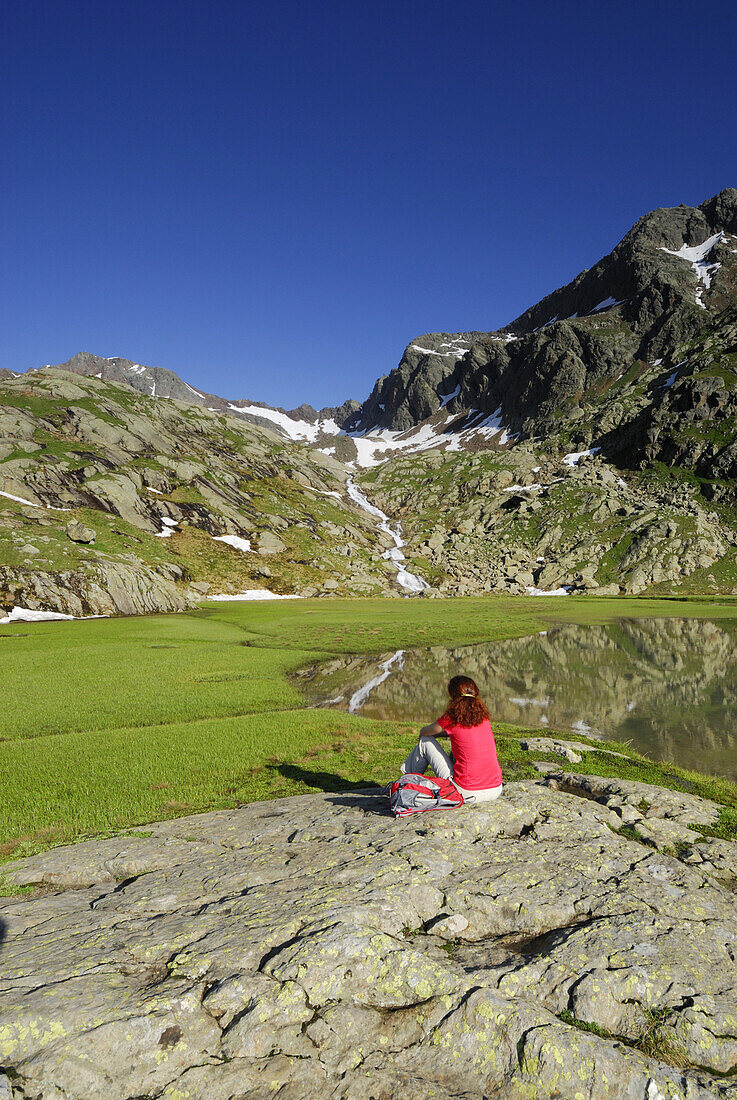 Woman resting at lake Stubensee, Stubai Alps, Trentino-Alto Adige/South Tyrol, Italy