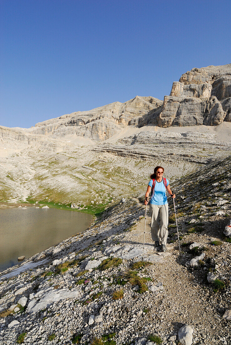 Woman hiking along lake Conturines, La Varella, Naturpark Fanes-Sennes-Prags, Dolomites, Trentino-Alto Adige/South Tyrol, Italy
