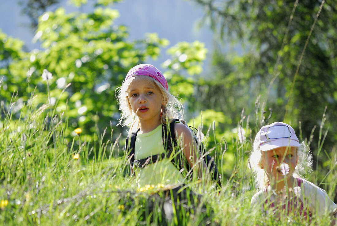 Zwei Mädchen in einer Wiese, Bayerische Alpen, Oberbayern, Bayern, Deutschland