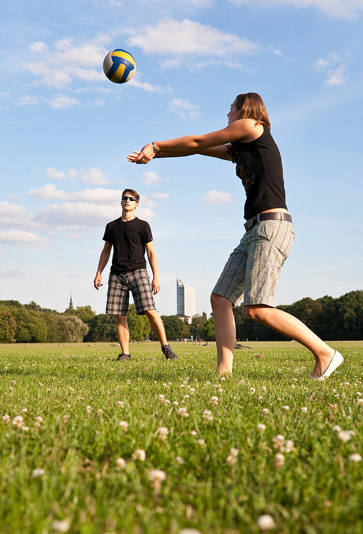 Young people playing volleyball on meadow, Leipzig, Saxony, Germany