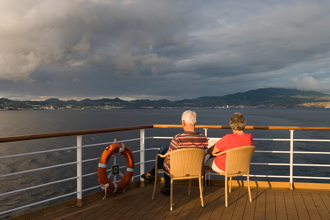 Menschen an Deck von Kreuzfahrtschiff MS Delphin Voyager (Delphin Kreuzfahrten) vor Ponta Delgada, Insel Sao Miguel, Azoren, Portugal, Europa