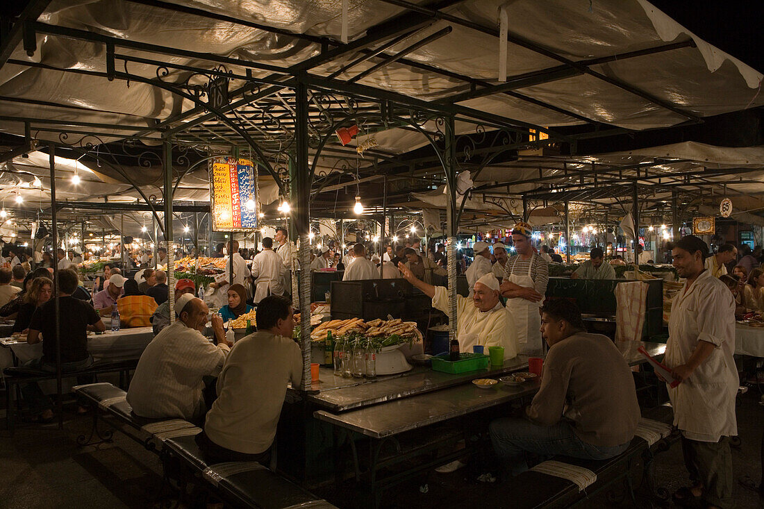 Patrons enjoying dinner at a food stall in Djemaa el Fna Square, Marrakesh, Morocco, Africa