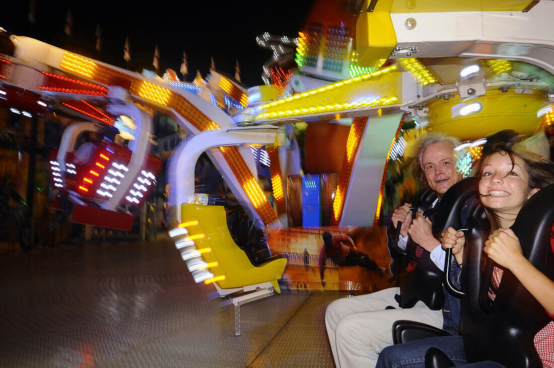 Ein Mann und ein Mädchen auf einem Fahrgeschäft, Oktoberfest, München, Bayern, Deutschland, mit Release, Europa