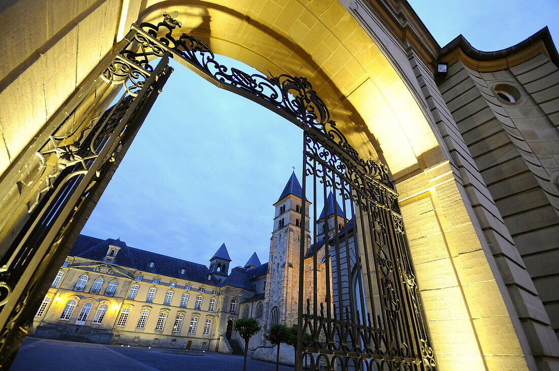 View through illuminated gate at the basilia in the evening, Echternach, Luxembourg, Europe