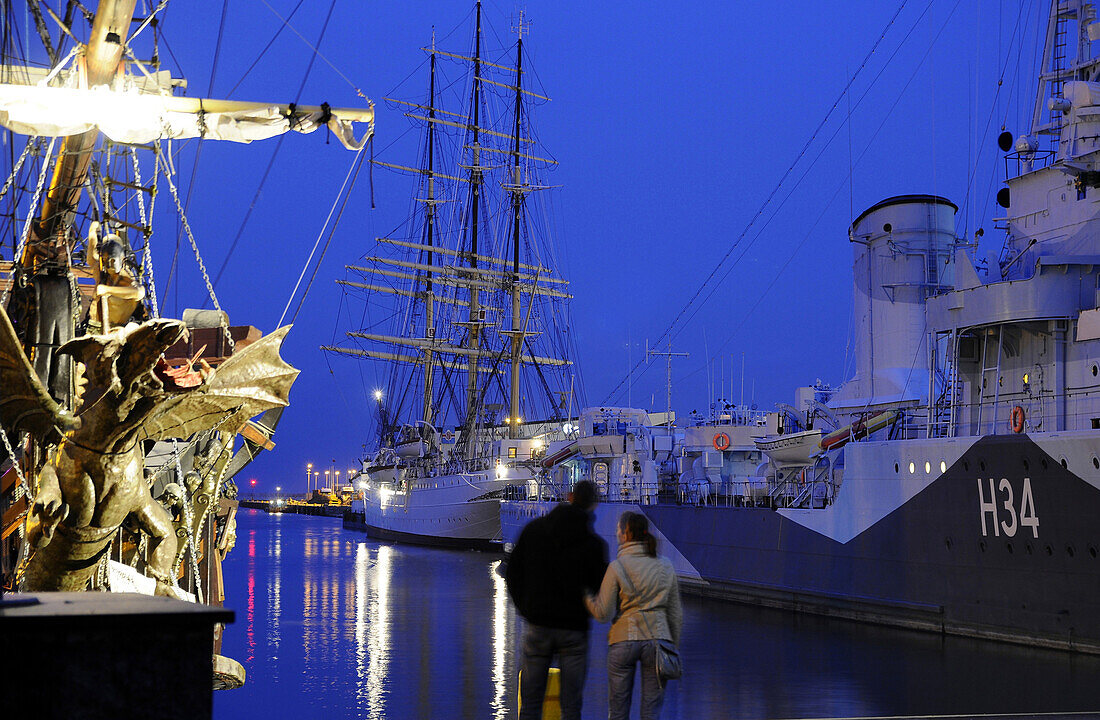 A couple in front of the museumship Dar Pormorza in Gdynia in the evening, Poland, Europe