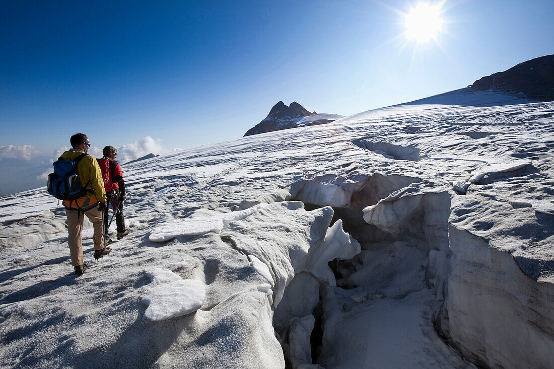 Zwei Bergsteiger wandern über Gletscherfeld am Hüfifirn, Claridengipfel im Hintergrund, Kanton Uri, Schweiz