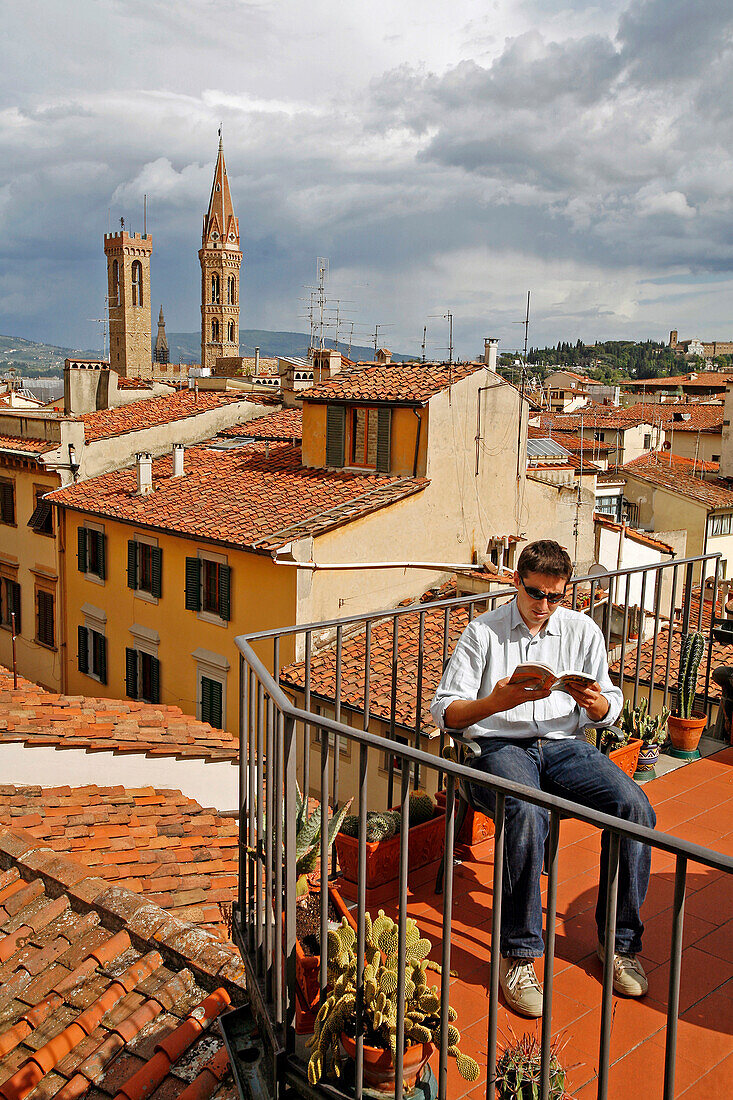 Customer On The Terrace Of The Hotel Brunelleschi With The Towers Of The Museo Nazionale Del Bargello And The Badia Fiorentina Church, Florence, Tuscany, Italy