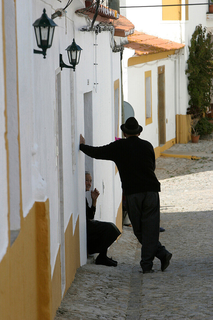 Locals Talking On A Small Street In The Village Of Terena, Alentejo, Portugal