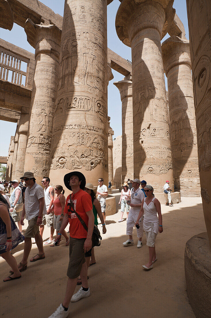Tourists between Pillars of Great Hypostyle Hall at Karnak Temple, Luxor, Egypt