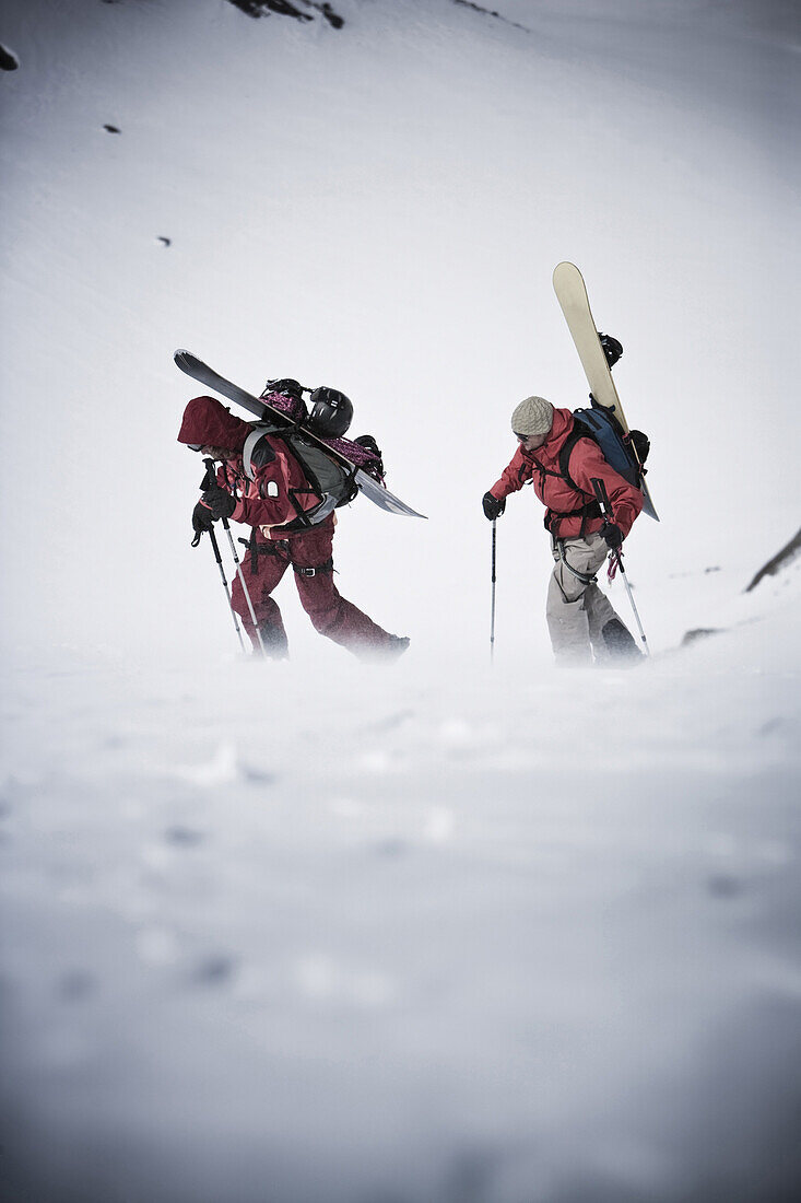 Two snowboarders ascending Zuckerhuetl, Gaiskogl in background, Stubai Alps, Tyrol, Austria
