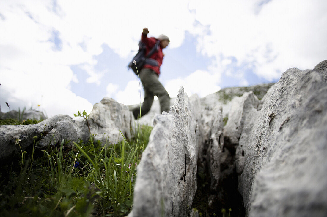 Junge Frau wandert über erodierten Kalk, Weissplatte, Montafon, Vorarlberg, Österreich