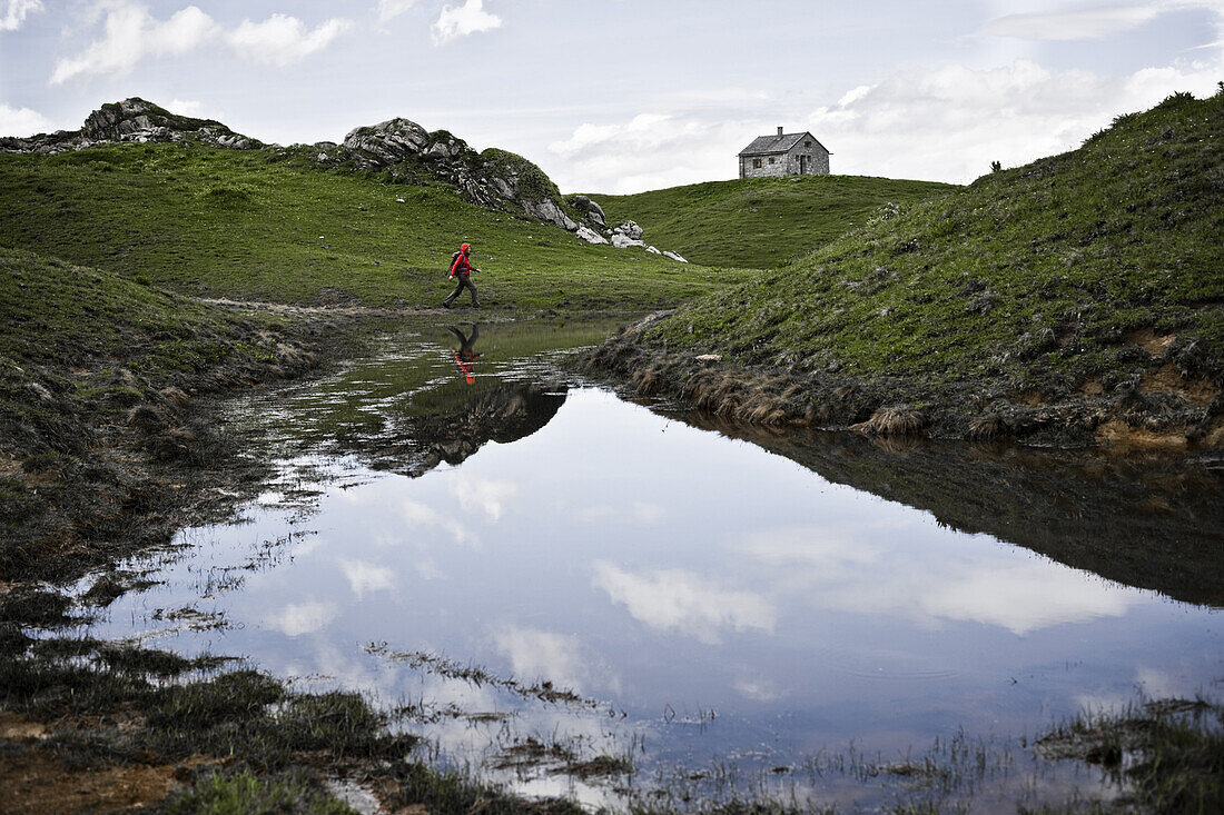 Hiker at lake, Raetikon Hoehenweg Nord, Montafon, Vorarlberg, Austria