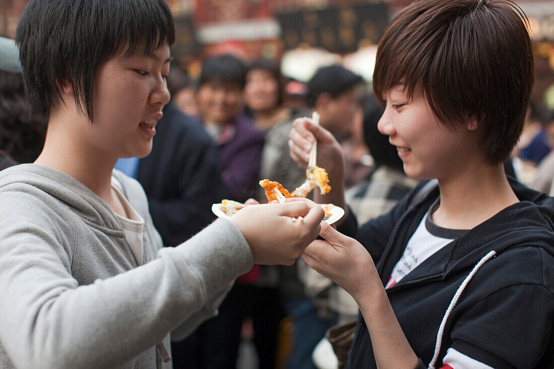 Two young women eating outside the Huxinting Teahouse, Yu Yuan Garden, Nanshi, Feng Shui, Shanghai, China, Asia