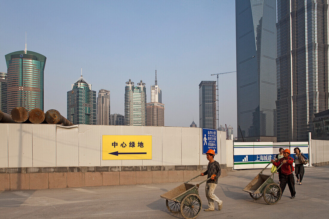 Bauarbeiter mit Schubkarre neben Jin Mao Tower, Pudong, Shanghai, China, Asien