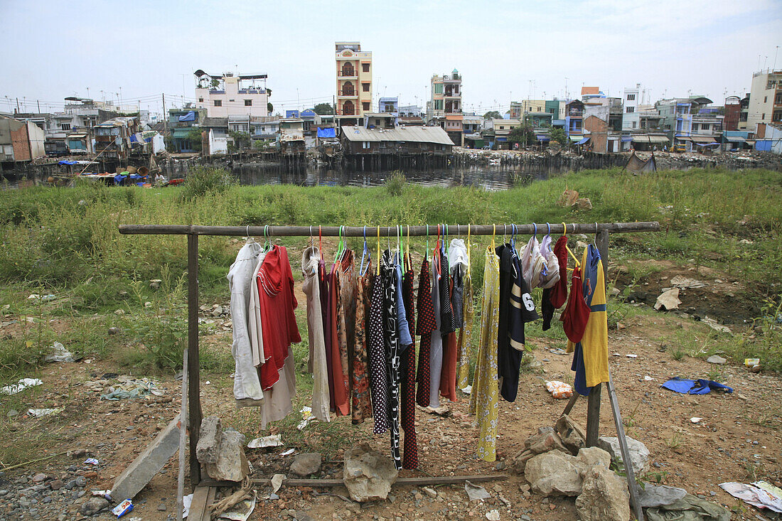 Kleiderständer mit Kleidern in einem Slum an einem Kanal, Saigon, Ho-Chi-Minh Stadt, Vietnam, Asien