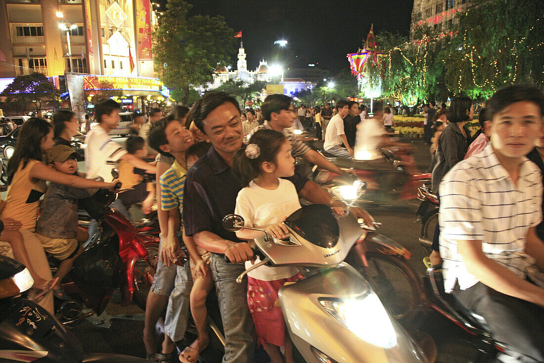 Menschen fahren auf Motorrollern während des Tet Fests bei Nacht, Saigon, Ho Chi Minh Stadt, Vietnam, Asien