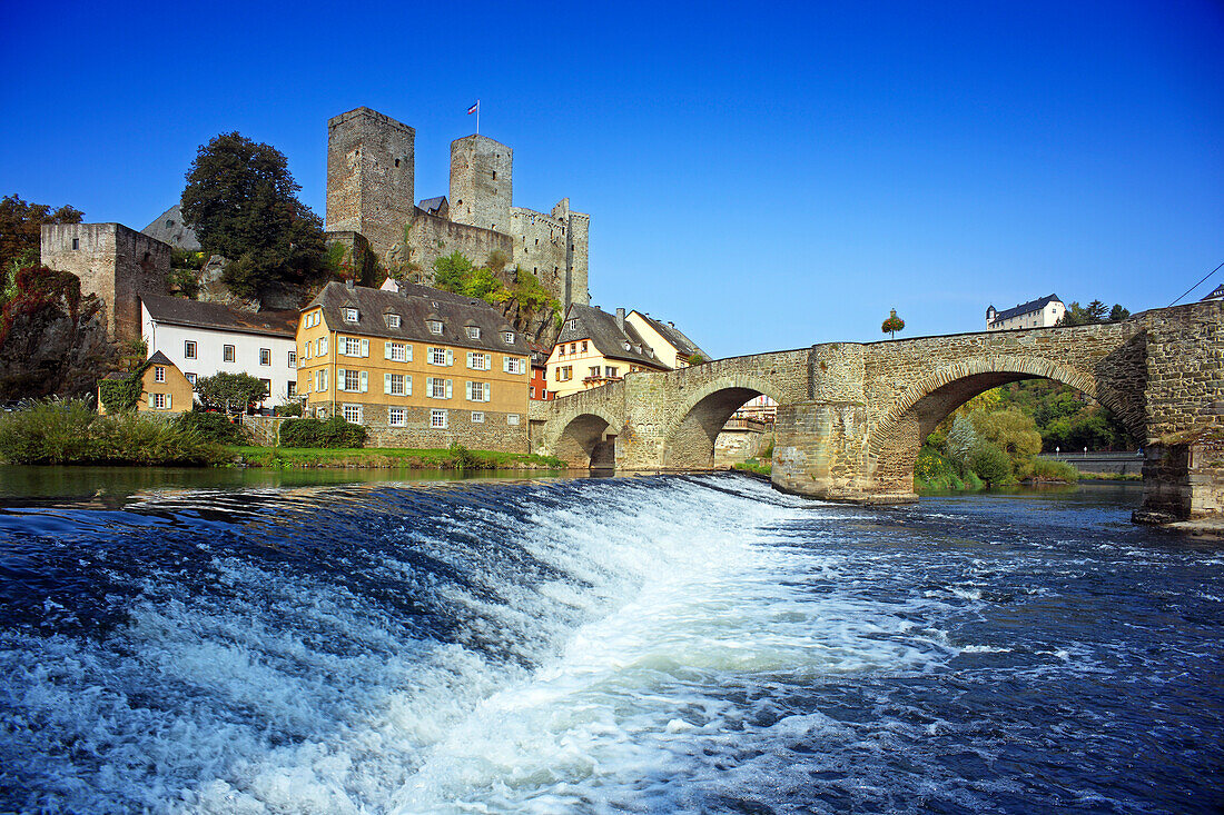 View over Lahn river with stone bridge to castle ruin, Runkel, Hesse, Germany