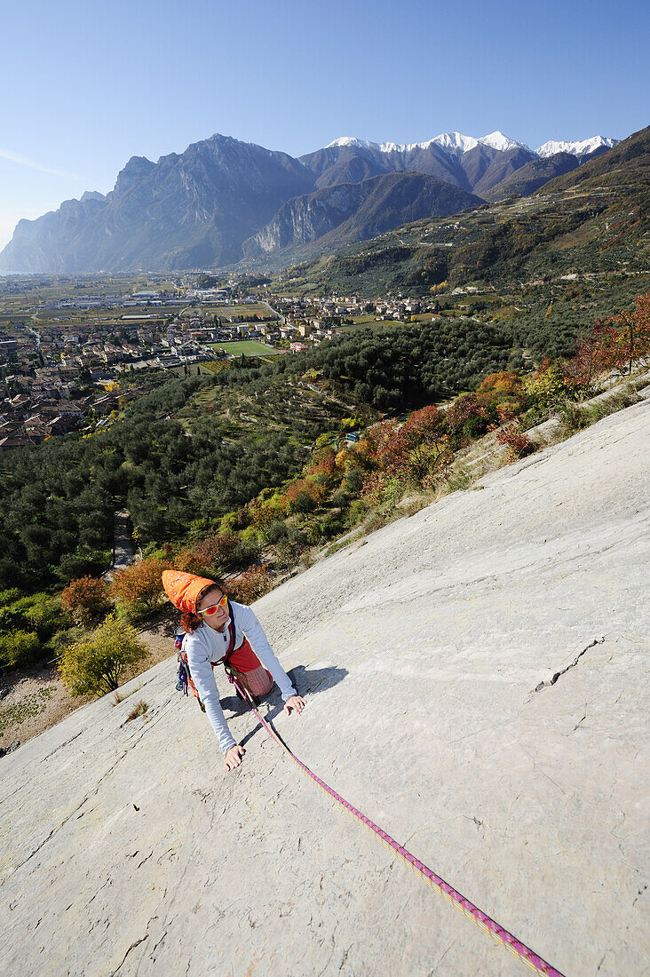 Frau klettert an einer Felswand, Gardasee, Arco, Trentino-Südtirol, Italien